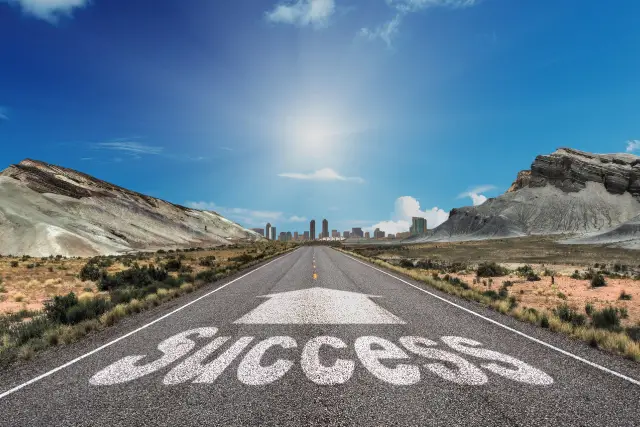 Road that has the word "success" and an arrow pointed forward on it