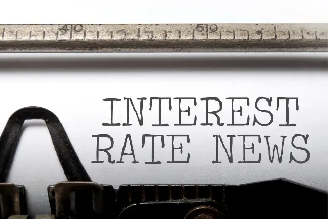 Typewriter writing "interest rate news", which is the Fed raising interest rates. 