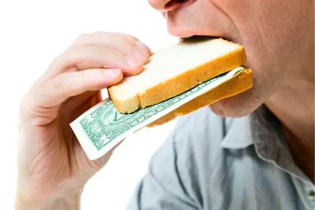 Man eating sandwich with dollar in it representing inflation