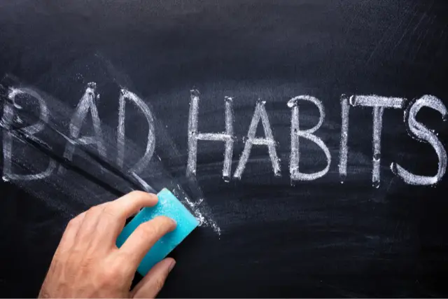 The word bad habits being erased from a black board