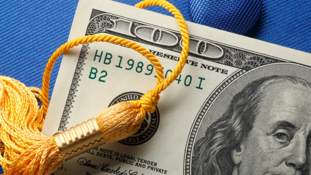 One hundred dollar bill with a graduation tassle on the corner
