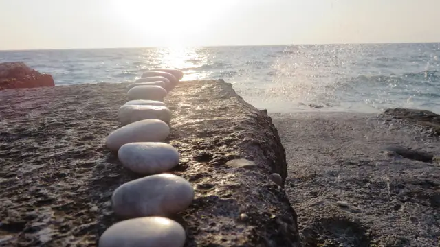 Rocks lined up in a row near the ocean like little goals or steps leading towards your FIRE goal