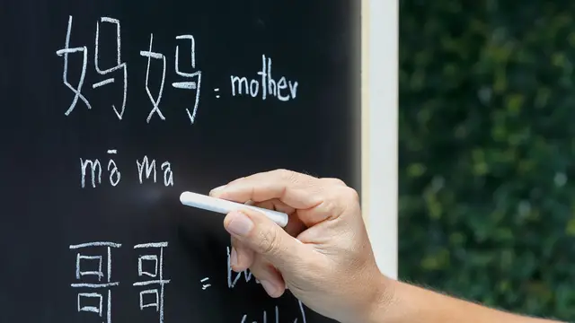 teacher writing chinese pinyin on blackboard 