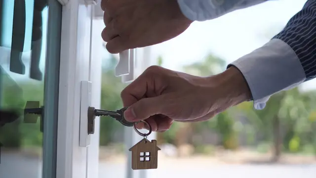 Landlord using a key to open up his or her rental property. 