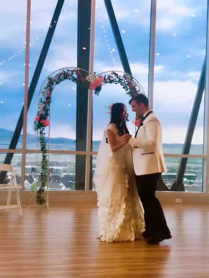 My wife and I dancing at our wedding with the affordable floral wedding arbor or arch in that background
