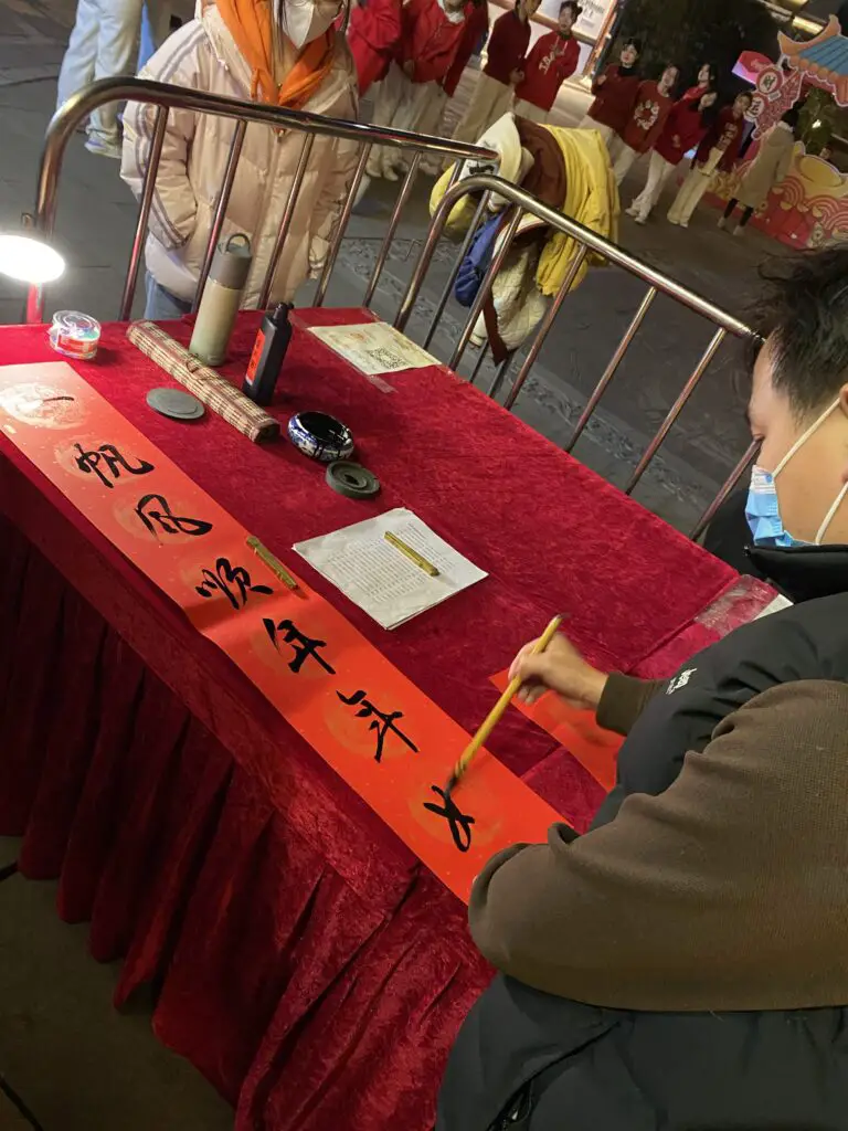 Person drawing beautiful chinese characters outside 