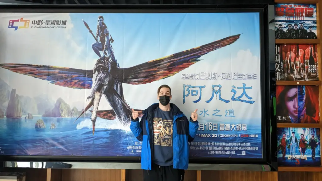 Me in front of an Avatar 2 movie banner in a Chinese movie theatre