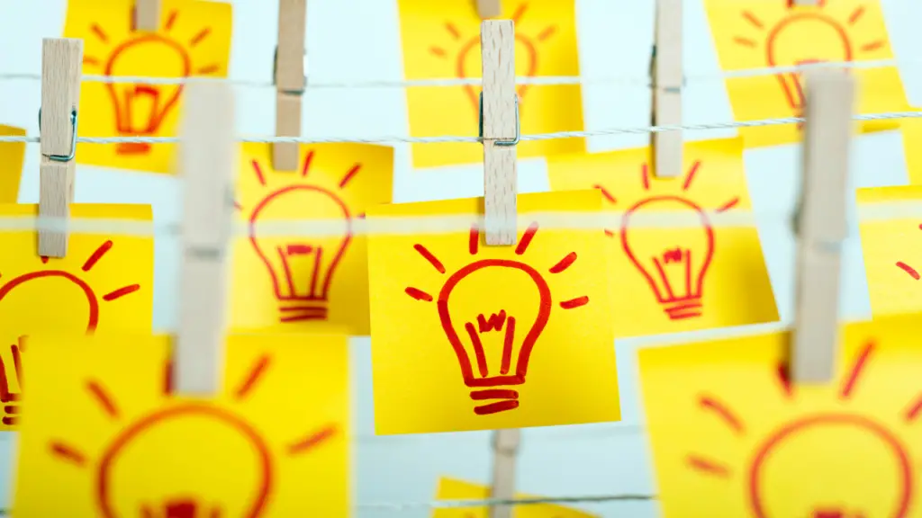 A bunch of light bulbs drawn on sticky notes and clipped onto a thin rope.